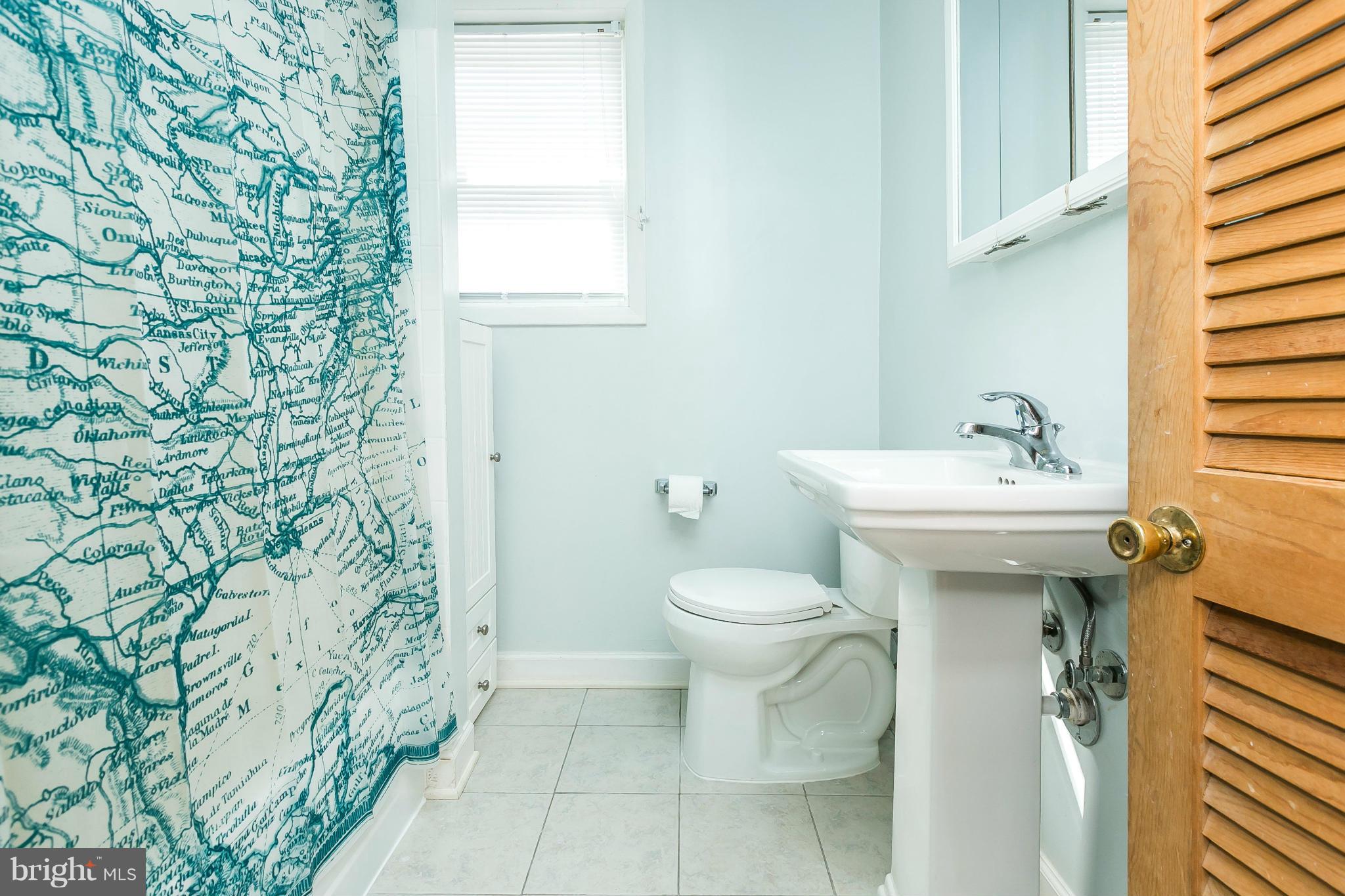3609 Yolando Road Baltimore, MD 21218 - Photo 22 of 27 a bathroom with a sink a toilet and shower curtain