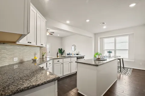 a kitchen with stainless steel appliances granite countertop a sink stove and cabinets