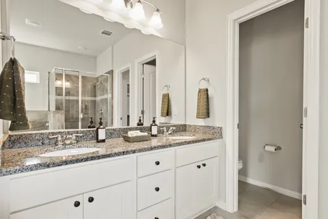 a bathroom with double sink and a mirror