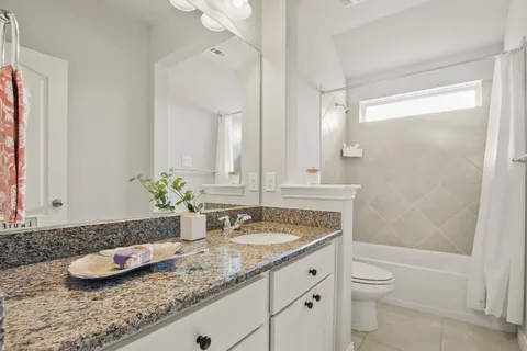 a bathroom with a granite countertop sink and a mirror a toilet
