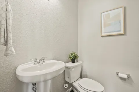 a bathroom with a sink mirror and toilet