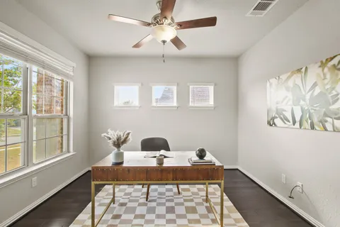 a view of a workspace with furniture and a window