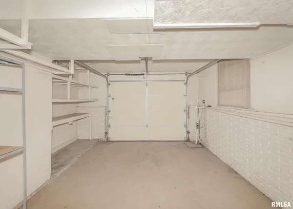 an empty room with windows and fireplace