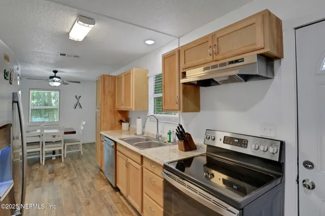 a kitchen with stainless steel appliances granite countertop a refrigerator and a stove