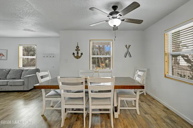 a dining room with wooden floor and a chandelier