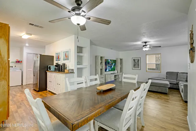 a kitchen with stainless steel appliances kitchen island granite countertop a table chairs and a refrigerator