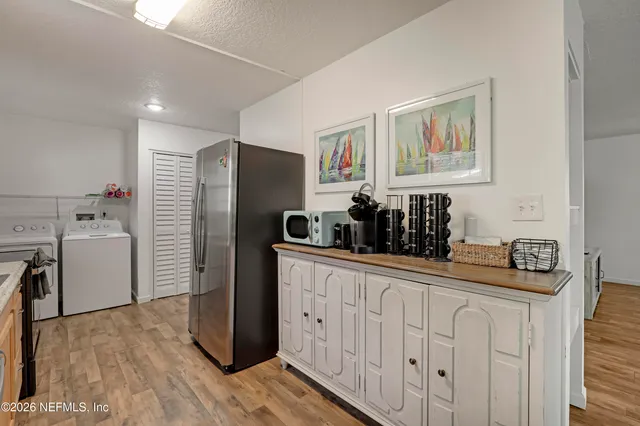 a kitchen with a sink refrigerator and cabinets