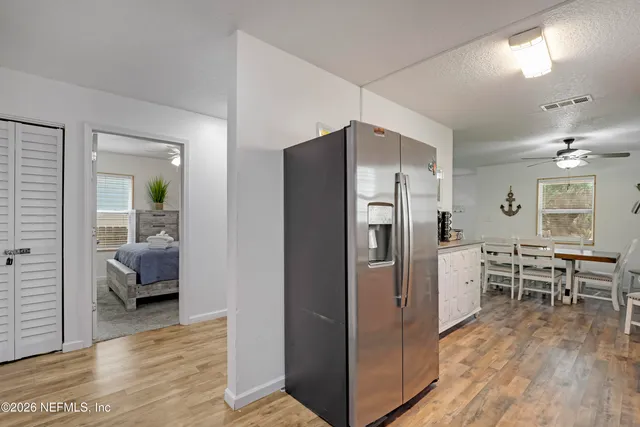 a kitchen with stainless steel appliances a refrigerator and wooden floor