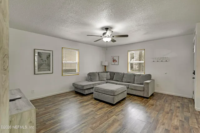 a living room with couches and paintings on the wall
