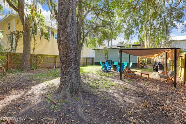 a view of a backyard with large tree and a large tree