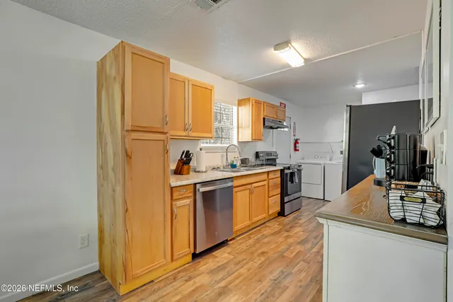 a kitchen with stainless steel appliances granite countertop a stove a sink and a refrigerator