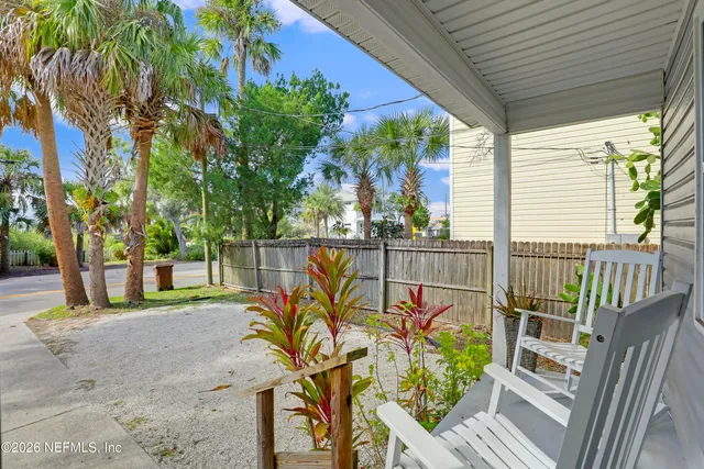 a view of a deck with wooden floor and fence next to a yard