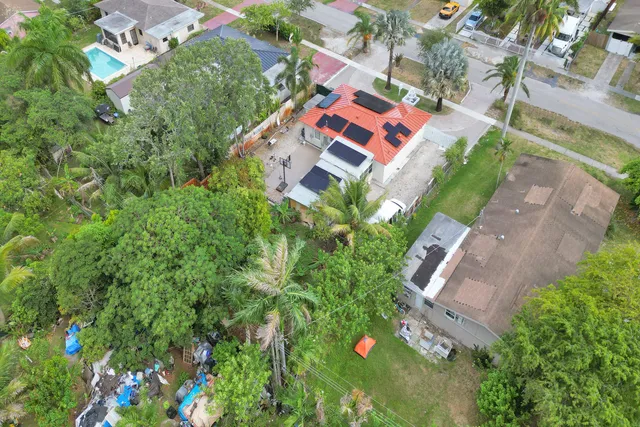 an aerial view of residential house with outdoor space and trees all around