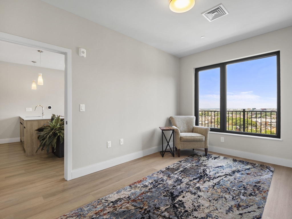 249 Corey Road, Unit 404 Boston, MA 02135 - Photo 10 of 30 a living room with furniture and a large window