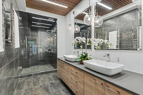a bathroom with a granite countertop sink a mirror and shower