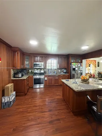a kitchen with stainless steel appliances granite countertop a stove and a large refrigerator