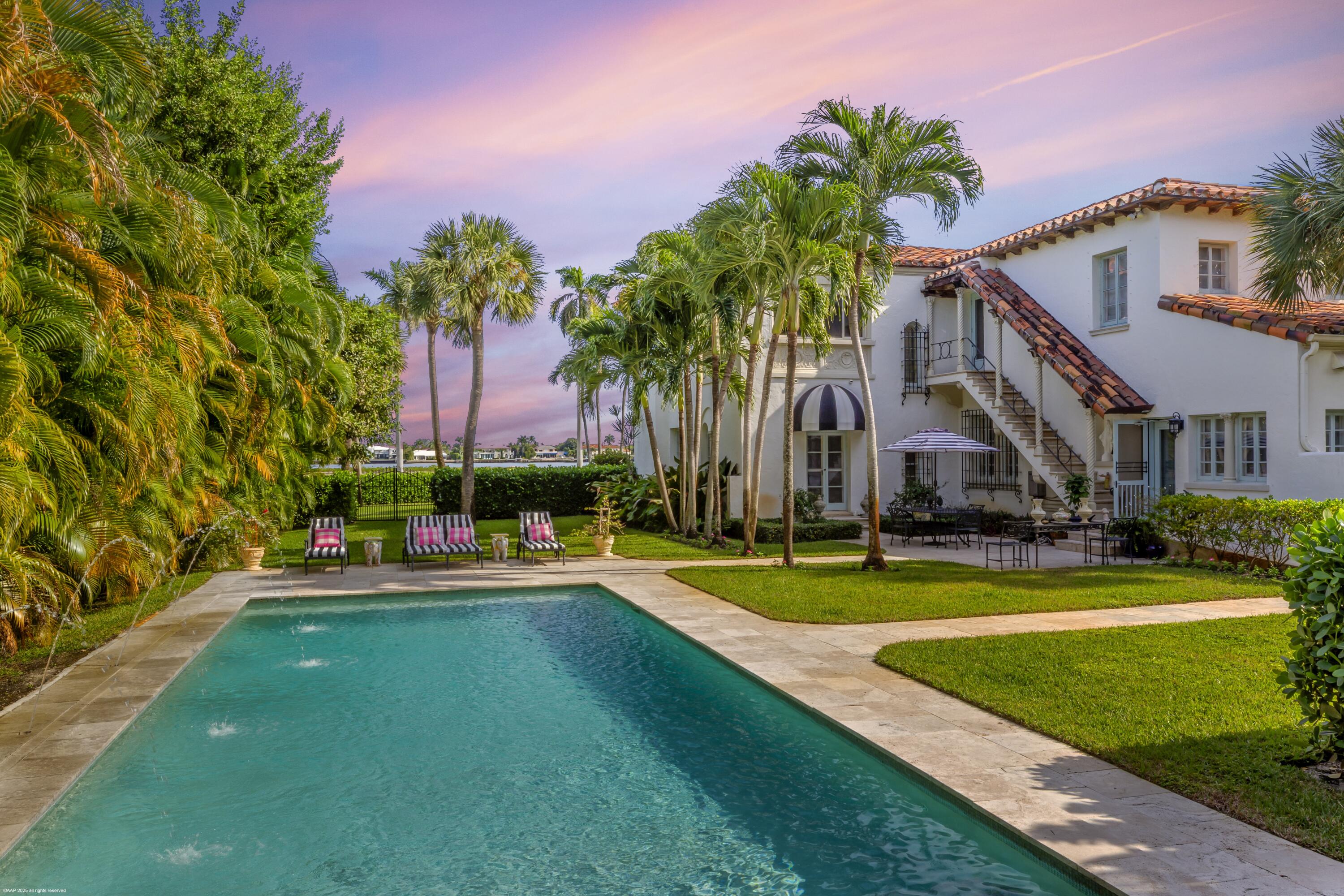 245 Valencia Road West Palm Beach, FL 33401 - Photo 32 of 39 a view of a swimming pool with a yard and palm trees