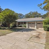 a view of house with yard and tree in front of it