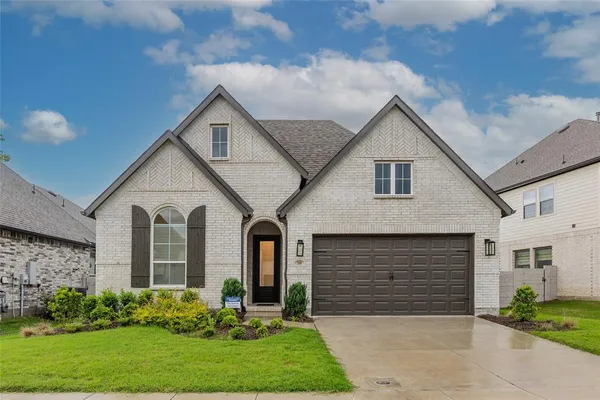 a front view of a house with a garden and plants