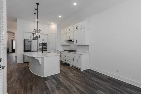 a view of kitchen with kitchen island stainless steel appliances wooden floor and living room view