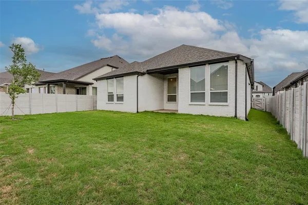 a front view of house with yard and trees in the background