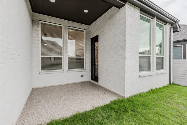 a aerial view of a house with table and chairs under an umbrella