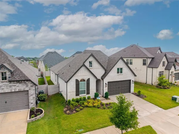 a aerial view of a house with a big yard plants and large tree