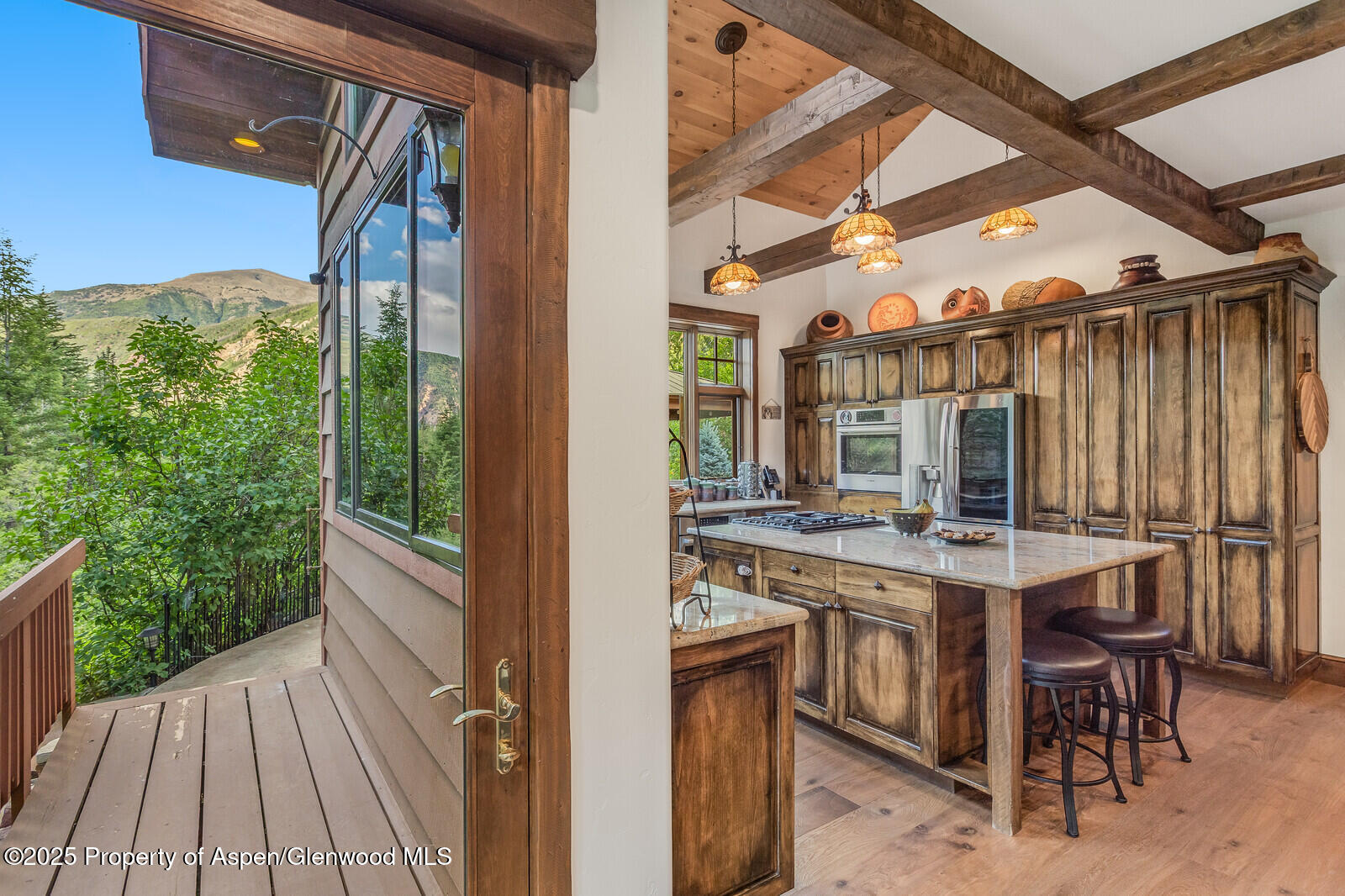606 Dorais Way Redstone, CO 81623 - Photo 36 of 103 a view of a patio with table and chairs a barbeque with wooden floor and fence