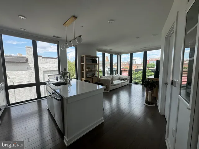 a view of a living room with hardwood floor and a large window