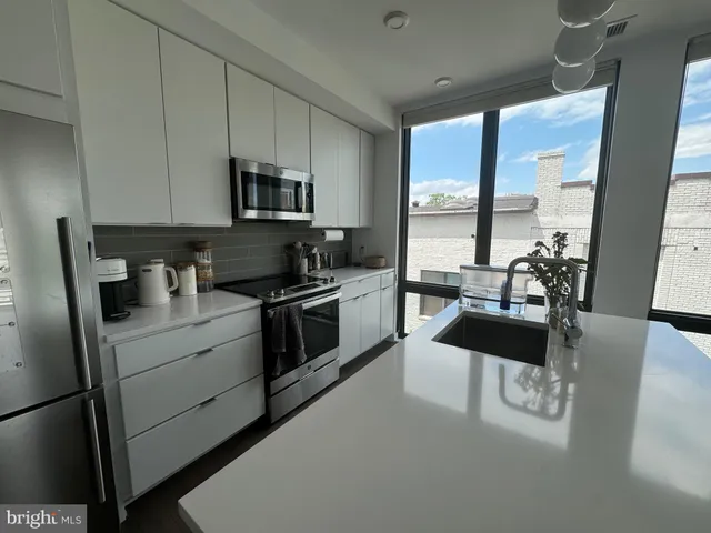 a kitchen with stainless steel appliances a sink a stove and a refrigerator