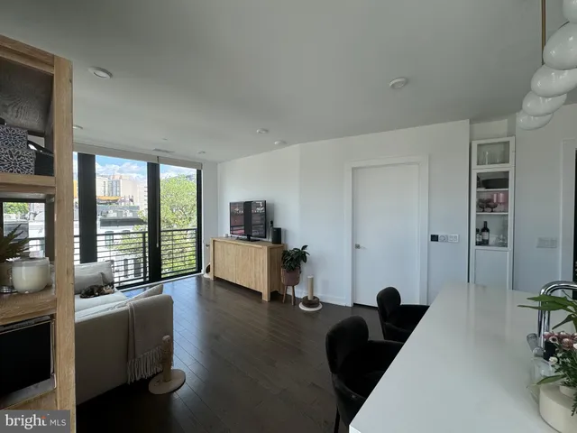 a living room with furniture floor to ceiling window and wooden floor
