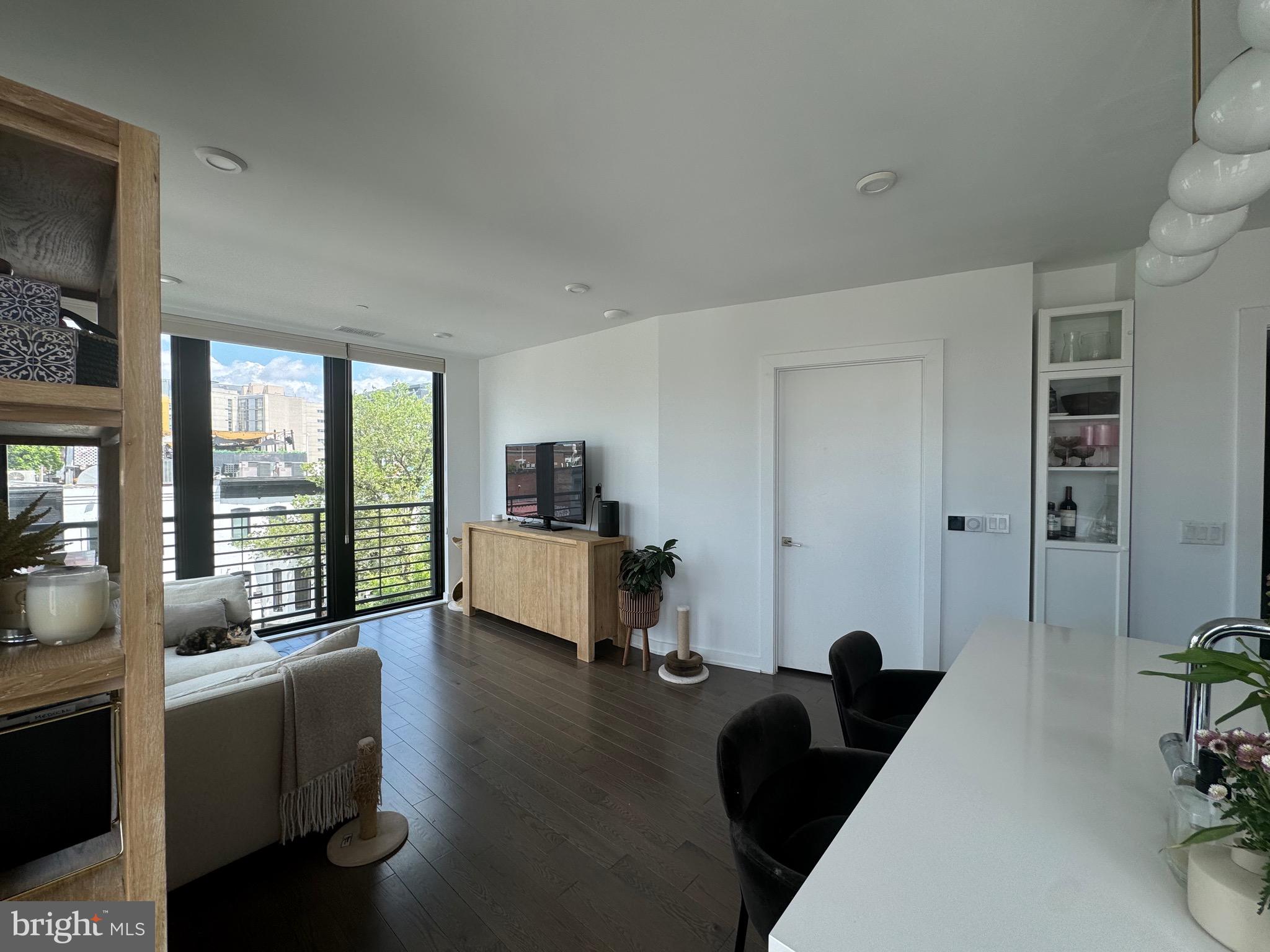 1999-9 1/2 9 1/2 Street Northwest, Unit 303 Washington, DC 20001 - Photo 4 of 14 a living room with furniture floor to ceiling window and wooden floor