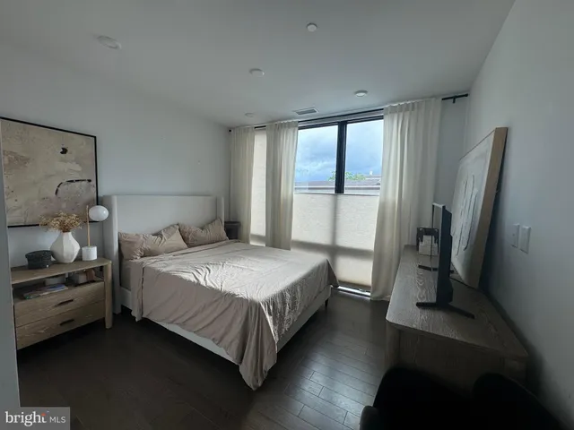 a bedroom with a bed and a large window