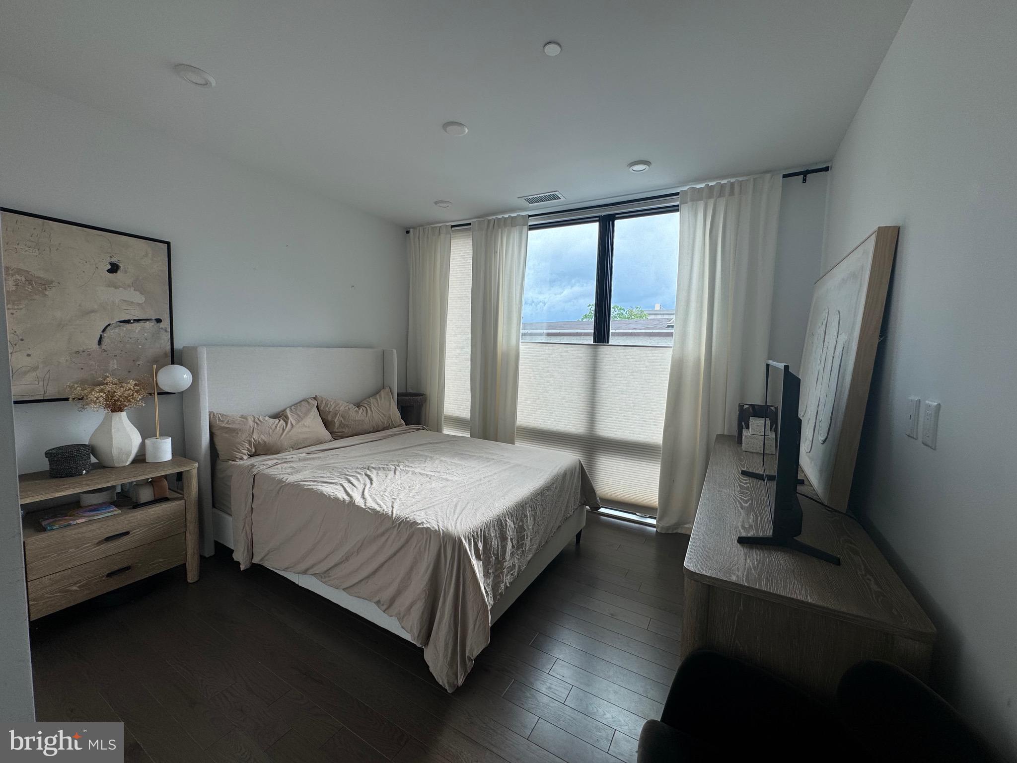 1999-9 1/2 9 1/2 Street Northwest, Unit 303 Washington, DC 20001 - Photo 6 of 14 a bedroom with a bed and a large window