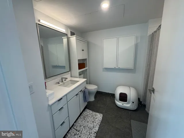 a bathroom with a sink and mirror with toilet