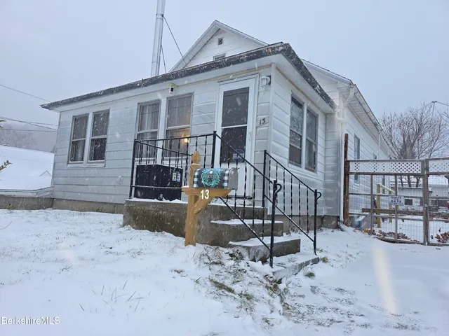a front view of a house with yard covered in snow