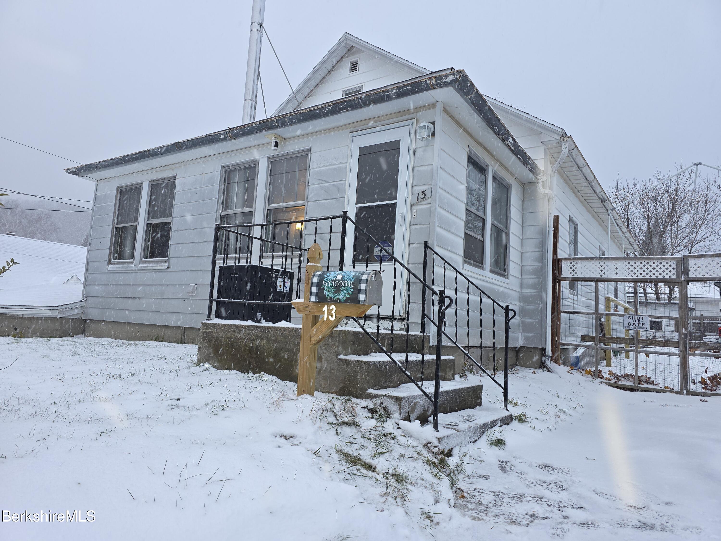 a front view of a house with yard covered in snow