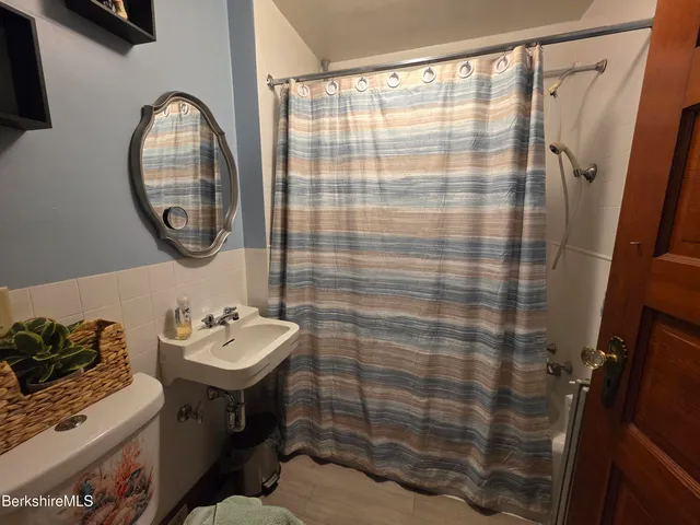 a bathroom with a sink a mirror and a shower curtain
