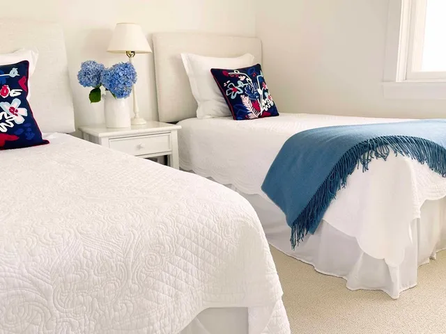 a bedroom with two beds and painting on the wall