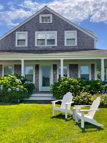 a front view of a house with a yard table and chairs