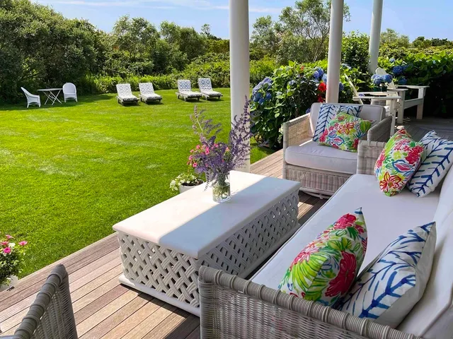 a view of a patio with couches table and chairs and potted plants