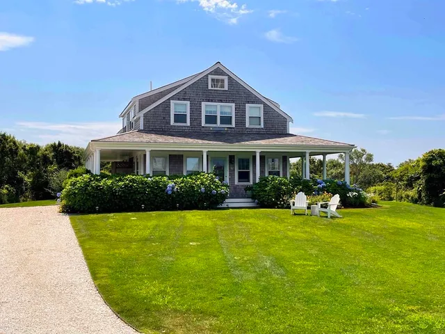 a front view of a house with swimming pool having outdoor seating