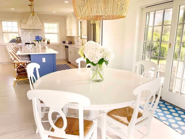 a dining room with wooden floor and large windows