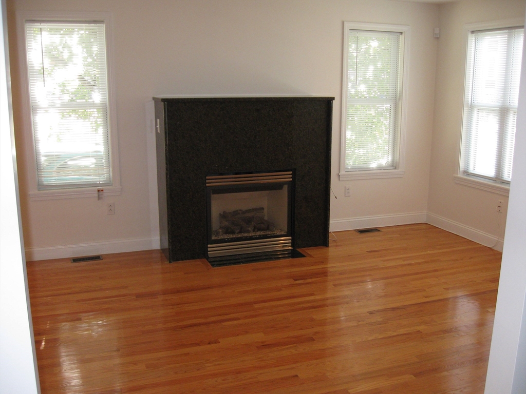2856 Washington Street Boston, MA 02119 - Photo 26 of 39 a view of empty room with wooden floor and fireplace