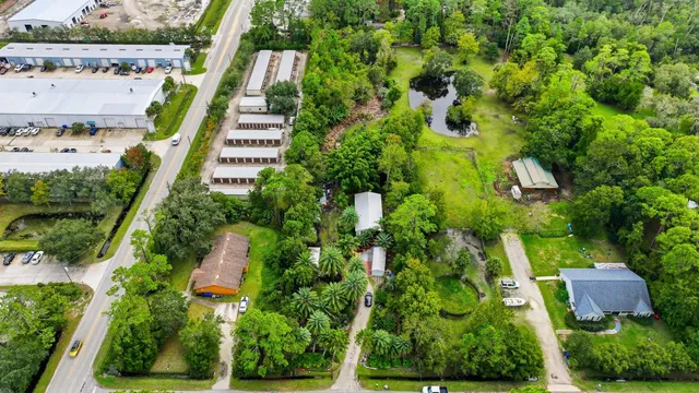 an aerial view of residential houses with outdoor space and trees
