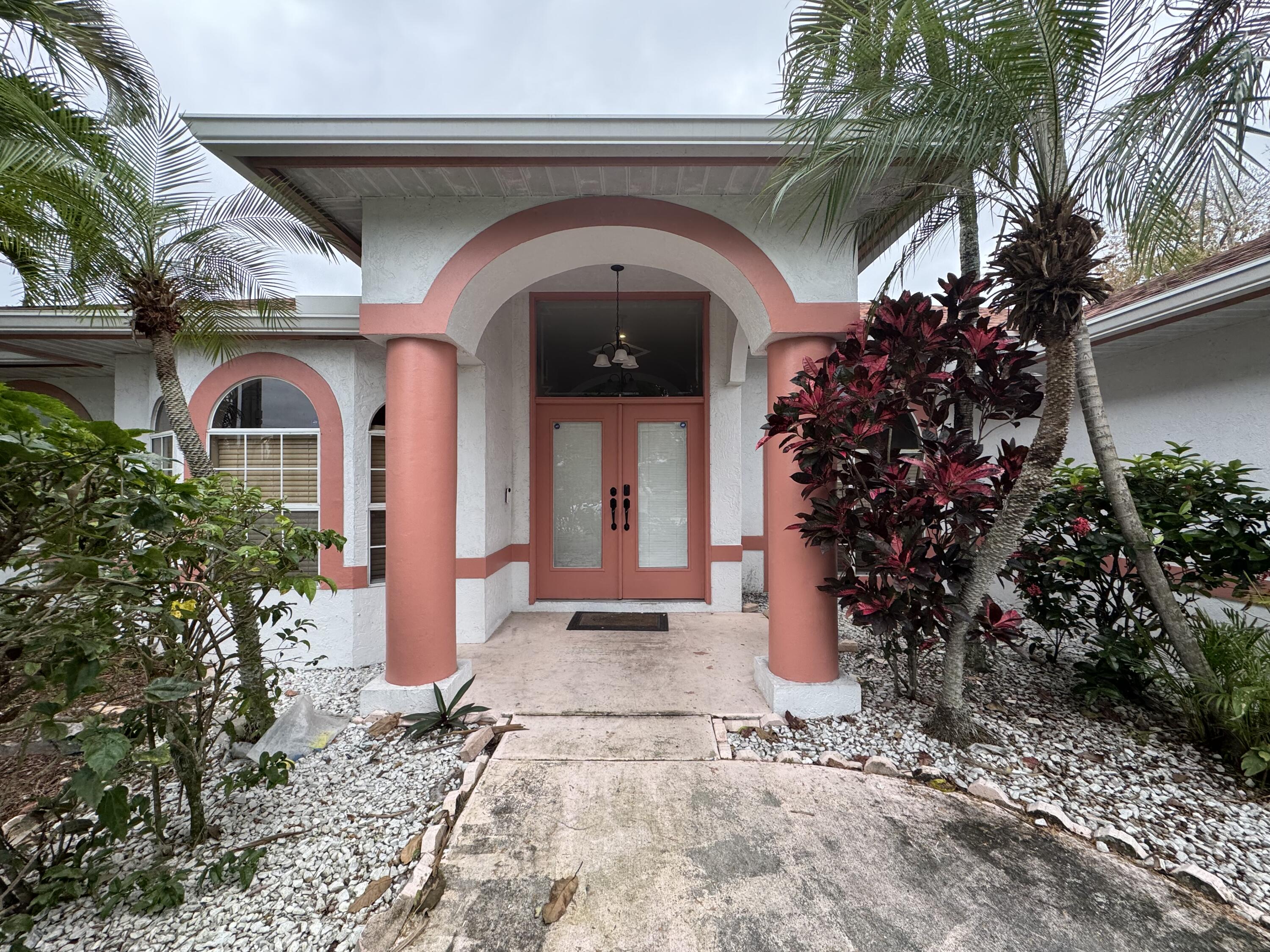 1872 Southwest Airoso Boulevard Port St. Lucie, FL 34984 - Photo 1 of 12 a view of a house with potted plants