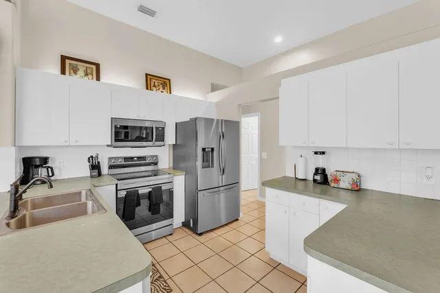 a kitchen with stainless steel appliances granite countertop a refrigerator sink and stove