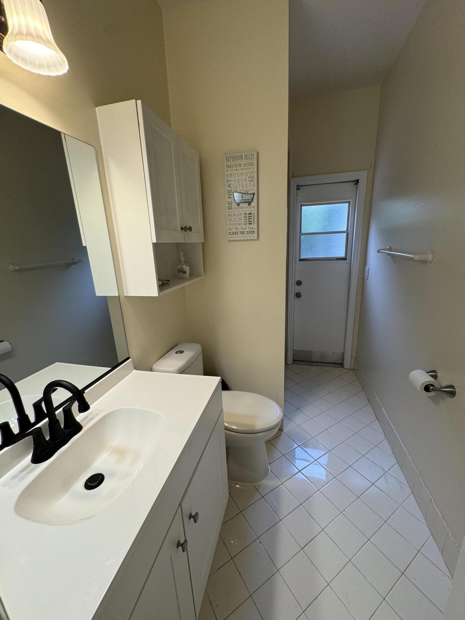1872 Southwest Airoso Boulevard Port St. Lucie, FL 34984 - Photo 12 of 12 a bathroom with a sink toilet and mirror