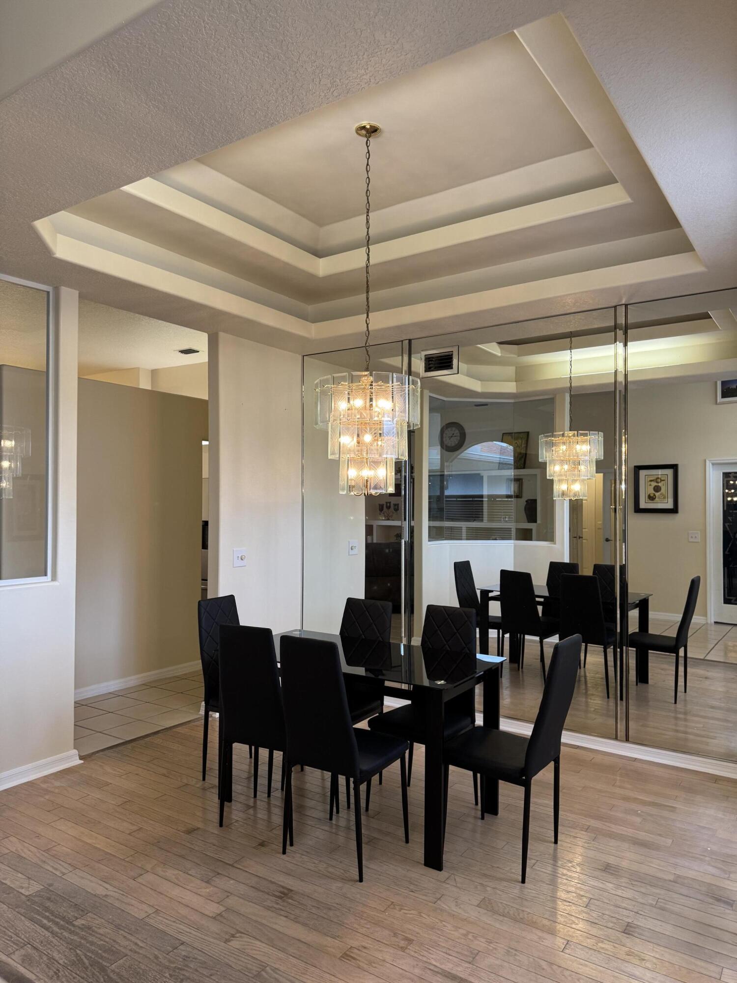1872 Southwest Airoso Boulevard Port St. Lucie, FL 34984 - Photo 3 of 12 a dining room with furniture wooden floor and a chandelier