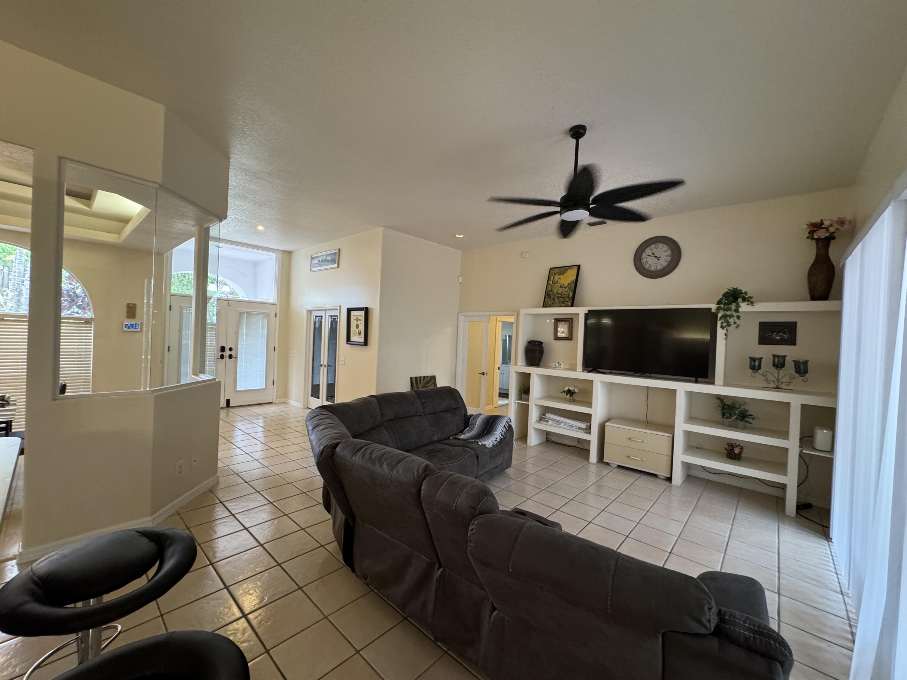 1872 Southwest Airoso Boulevard Port St. Lucie, FL 34984 - Photo 4 of 12 a living room with furniture a flat screen tv and a table